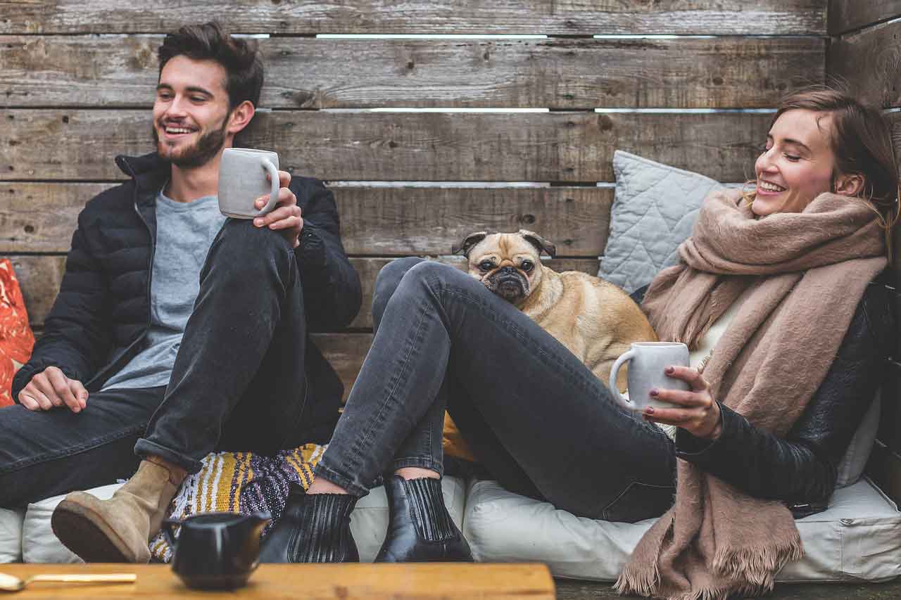  Man and woman relaxing while holding coffee mugs.