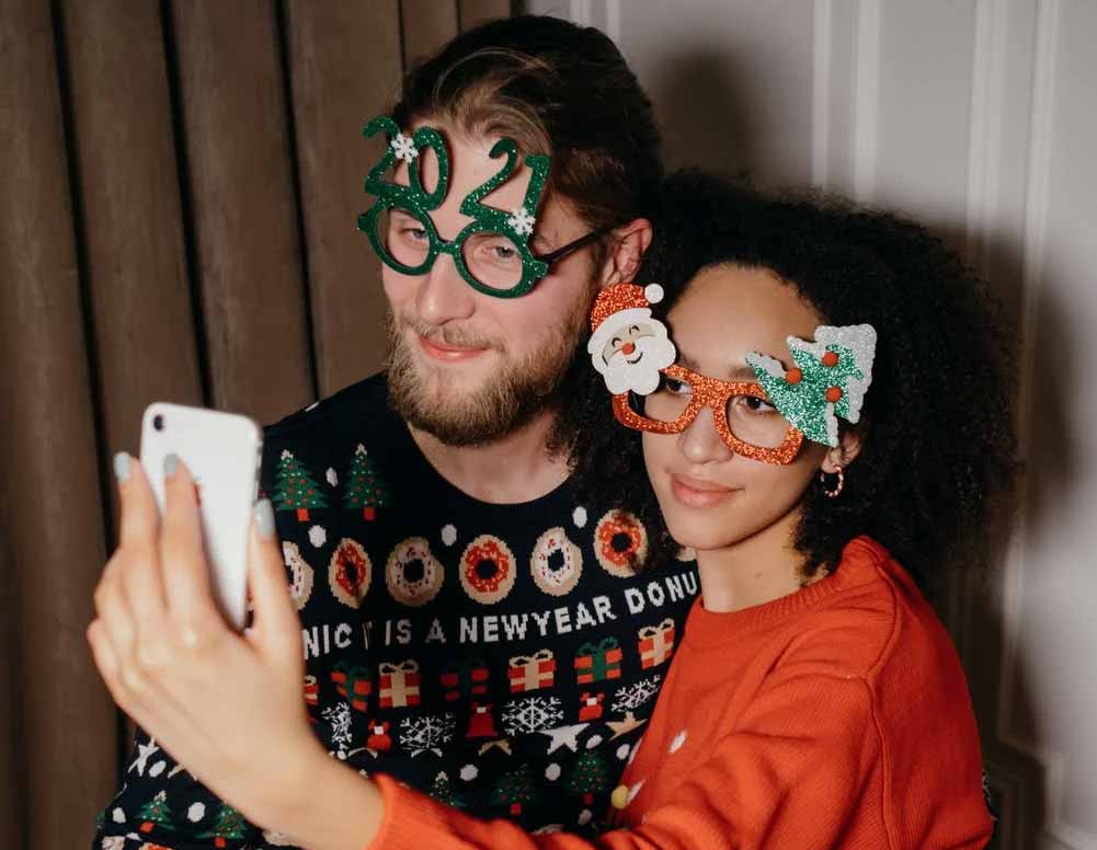 Man and woman dressed in New Year sweaters making a selfie