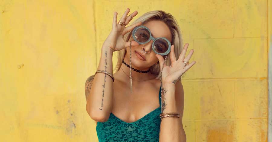 A Latina woman holding up glasses.