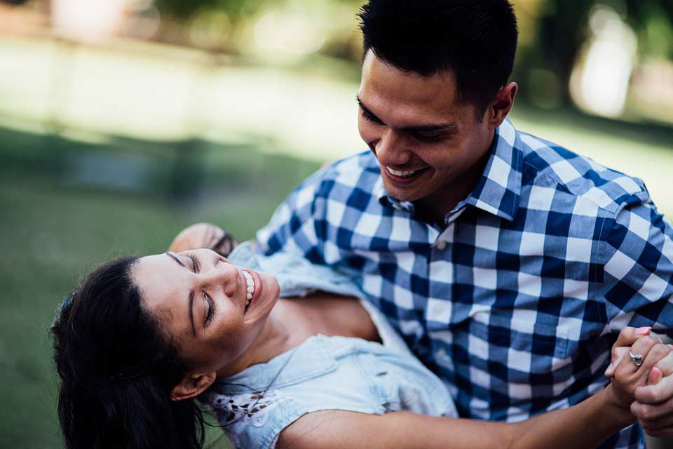 A photo of a happy couple dancing on a field.