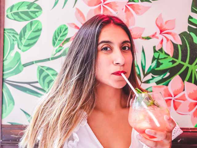  A photo of a Latin woman sipping on a cocktail drink