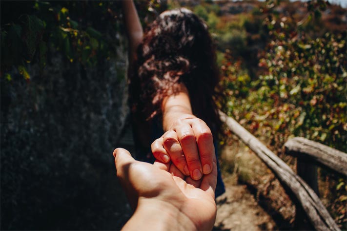 A photo of a Colombian woman holding a man’s hand